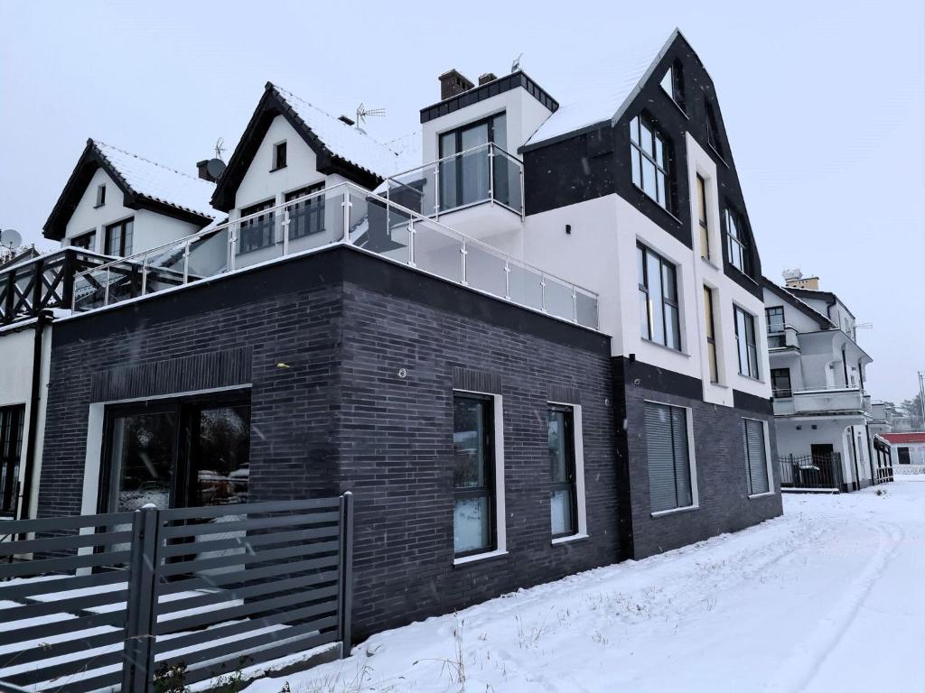 a black and white building in the snow at Luxurious holiday apartment in Mrze yno in Mrzeżyno
