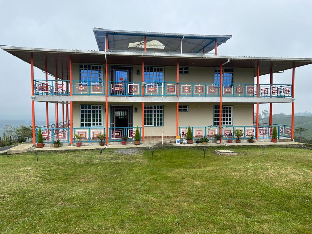 ein großes Gebäude mit Rasen davor in der Unterkunft Villa Jair Hotel in Filandia