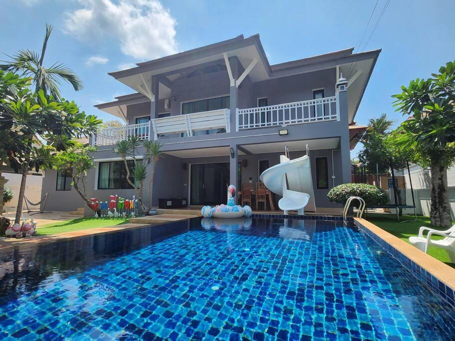una casa con piscina frente a una casa en D30长住优惠-市中心海边高端别墅区6间卧室泳池别墅 en Pattaya centro