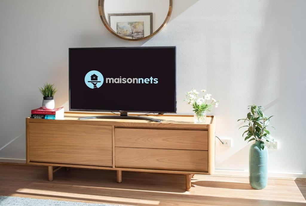 a television on top of a wooden entertainment center in a living room at Melbourne CBD Apt With A C Balcony & Pool in Melbourne