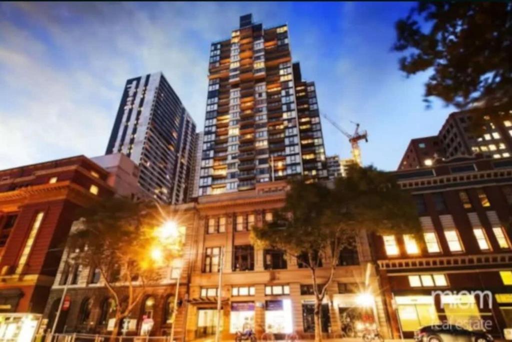 a tall building in a city with tall buildings at Melbourne CBD Apt With A C Balcony & Pool in Melbourne