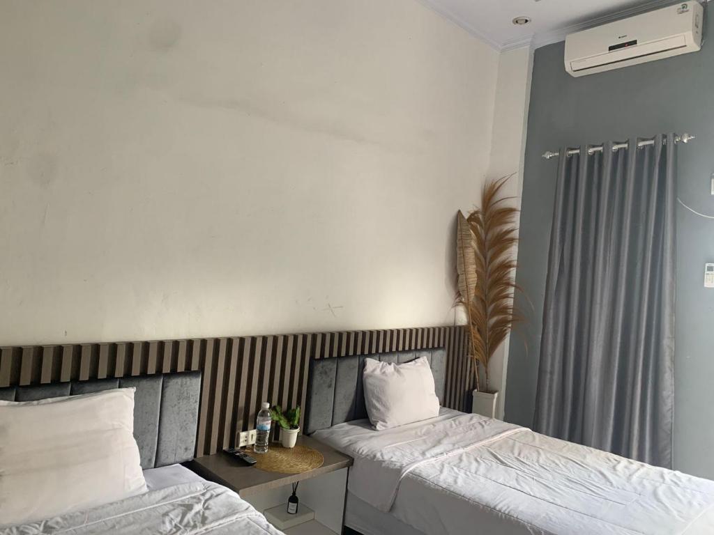 a bedroom with two beds and a radiator at Oemah Ratu Hostel Syariah RedPartner in Bandar Lampung