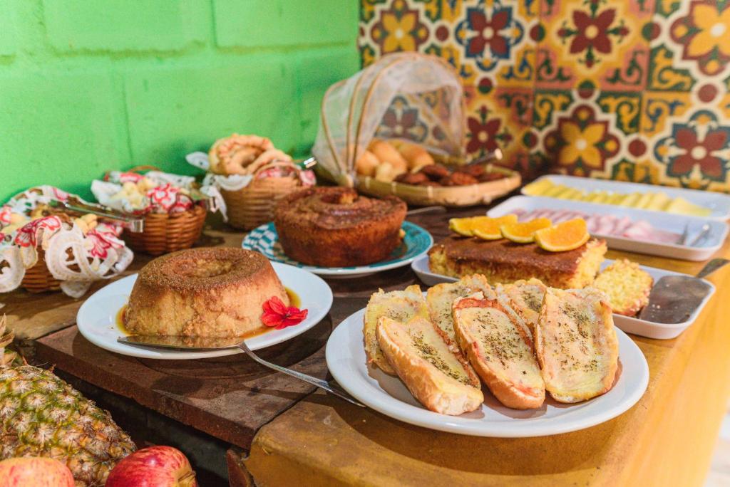 a table full of cakes and pastries on plates at Casa de fadas in Tiradentes