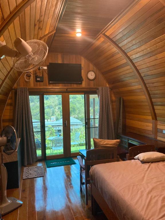 a bedroom with a bed and a ceiling fan at Seaview Eagles Nest Cabins in Rawai Beach