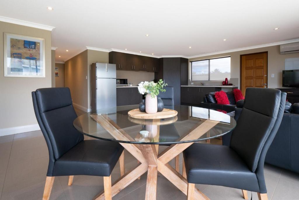 a dining room and kitchen with a glass table and chairs at Ocean View Executive Apartment 2 in Geographe