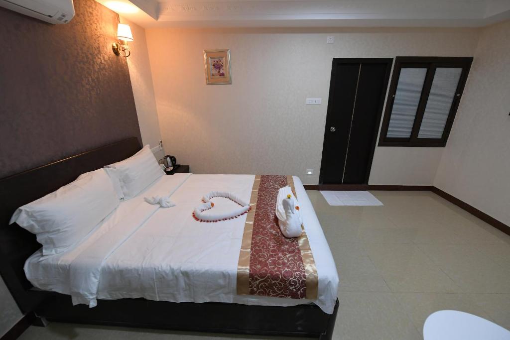 Una habitación de hotel con una cama con dos teléfonos. en Coastal Grand Hotel Sampath, en Tiruchchirāppalli