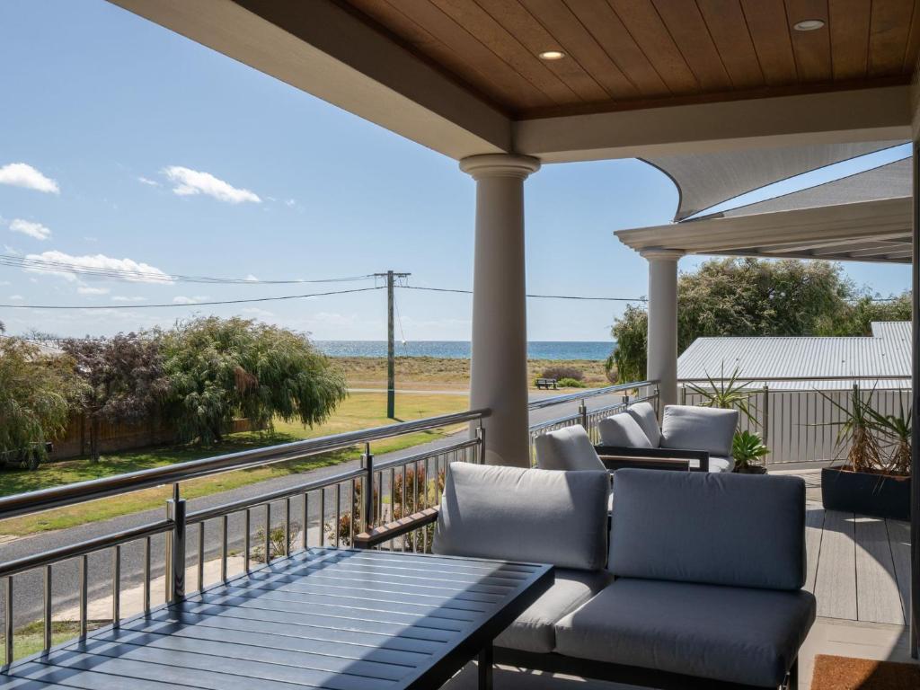 - une terrasse couverte avec des chaises et une vue sur l'océan dans l'établissement Ocean View Executive Apartment 4, à Geographe