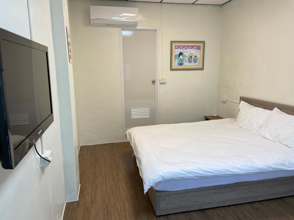 1 dormitorio con 1 cama y TV de pantalla plana en 佳林居, en Dahu