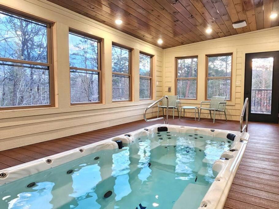 an indoor hot tub in a room with windows at A Splashing Good Time in Sevierville