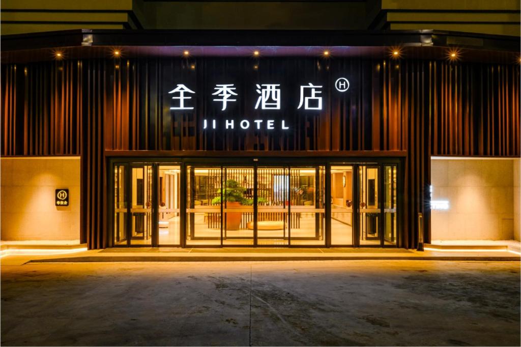 uma loja em frente a um hotel à noite em Ji Hotel Yantai Guanhai Road Fisherman's Wharf em Qianqikuang