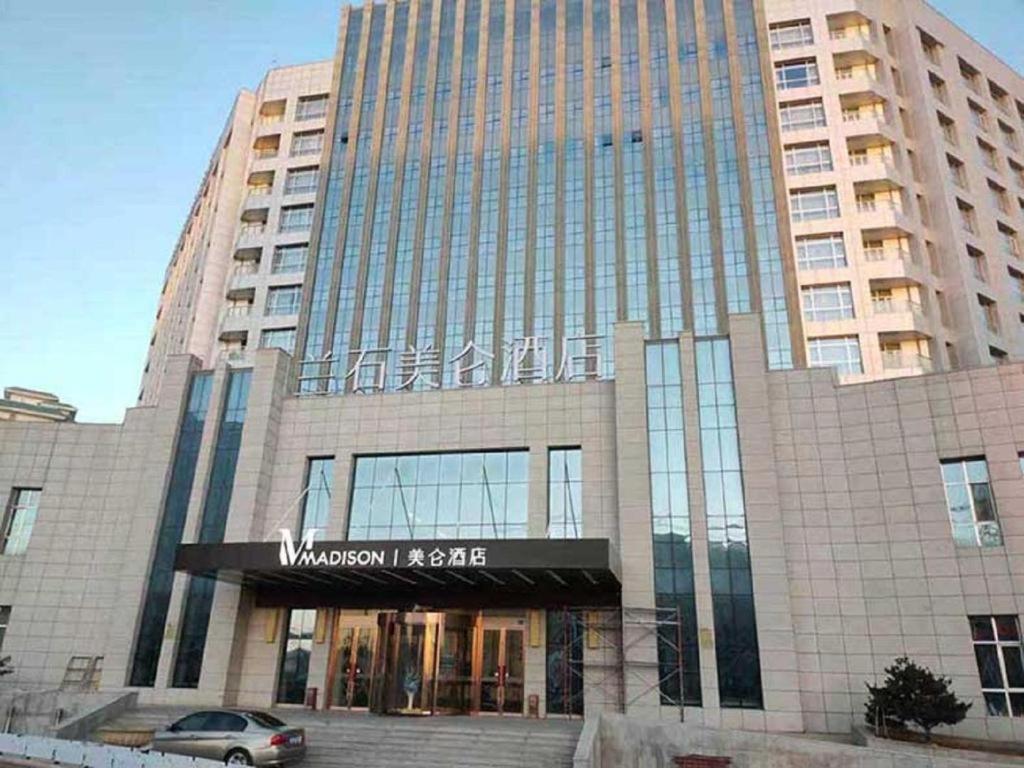 duży budynek z samochodem zaparkowanym przed nim w obiekcie Madison Lanzhou Lanshi Zhongchuan Airport w mieście Hejialiang