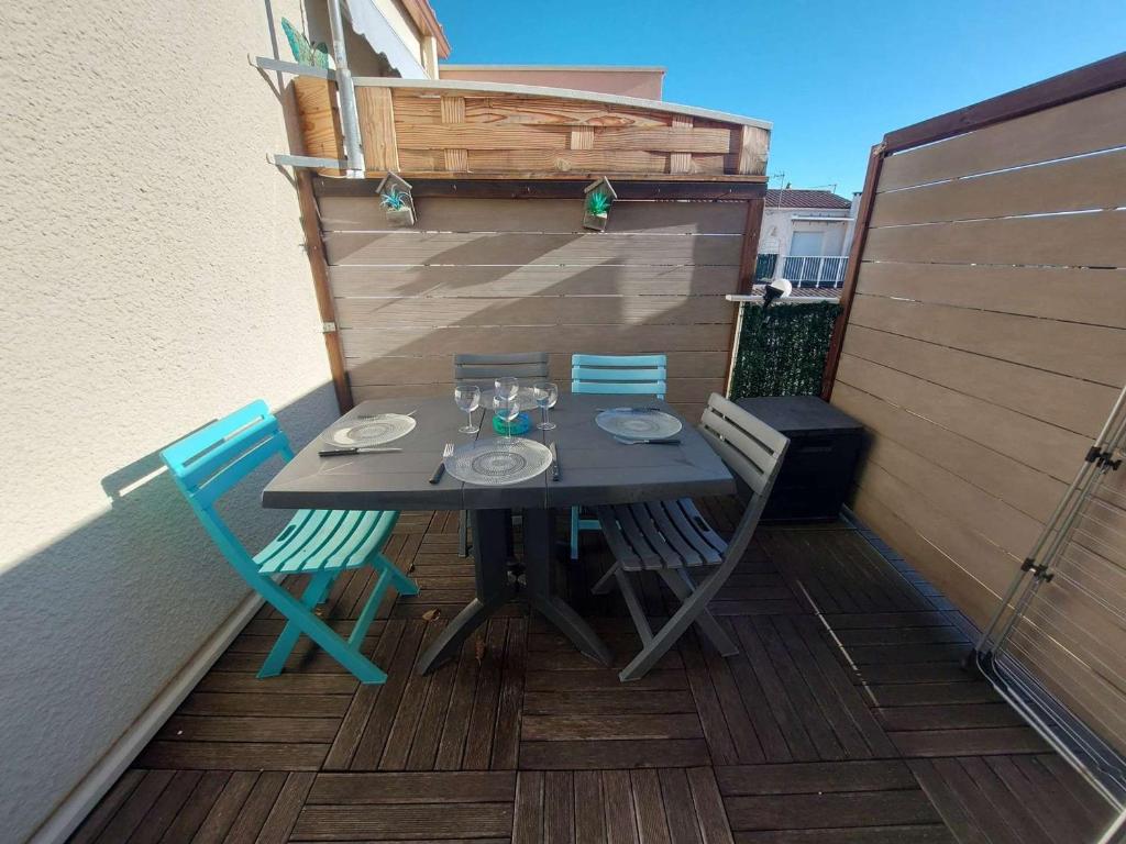 une table et des chaises assises sur une terrasse dans l'établissement Appartement Climatisé 4 Pers avec Terrasse et Parking à Marseillan - FR-1-326-808, à Marseillan