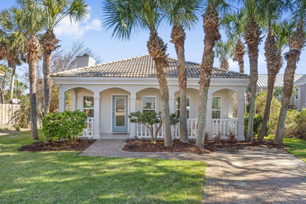 a white house with palm trees in front of it at Calatrava Beach Cottage Pet Family Friendly in Destin