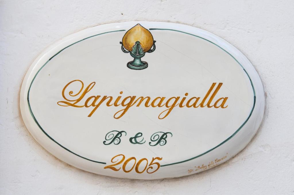 a sign for a restaurant with a candle on it at Lapignagialla in Martina Franca