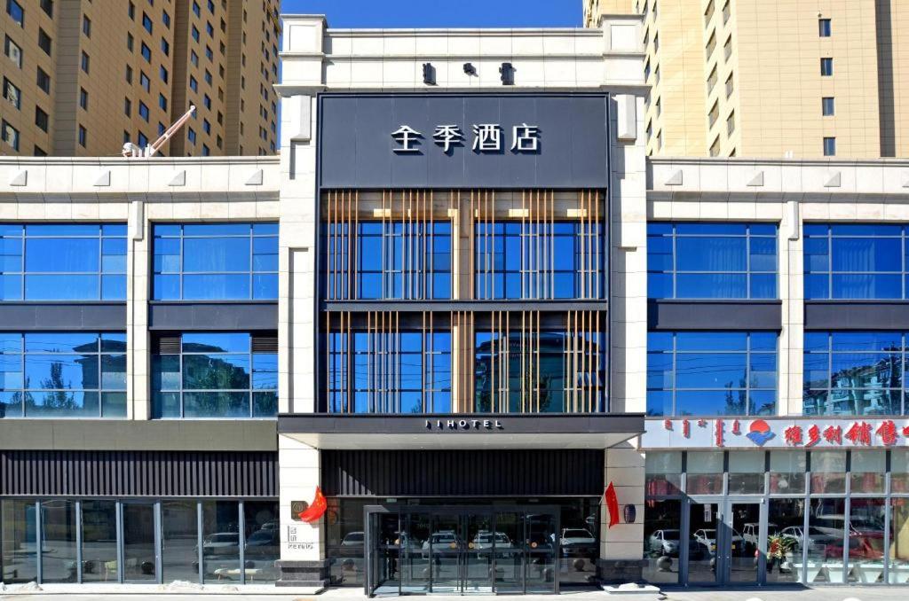 um edifício com um sinal asiático na parte da frente em Ji Hotel Ulanqab Victoria Square em Jining