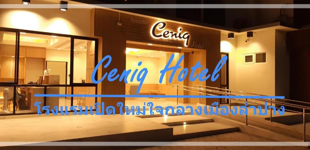 Ceniq Hotel في Ban Long: متجر أمام فندق مركزي مع علامة نيون