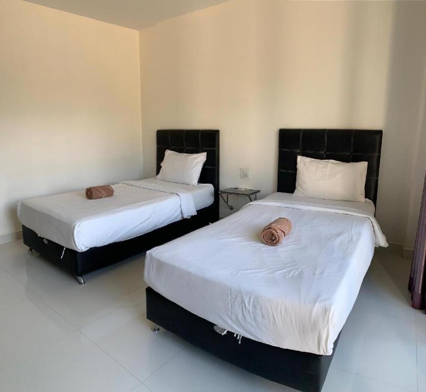 duas camas sentadas uma ao lado da outra num quarto em นิวธาราเพลส หล่มสัก โรงแรม em Ban Nam Phung