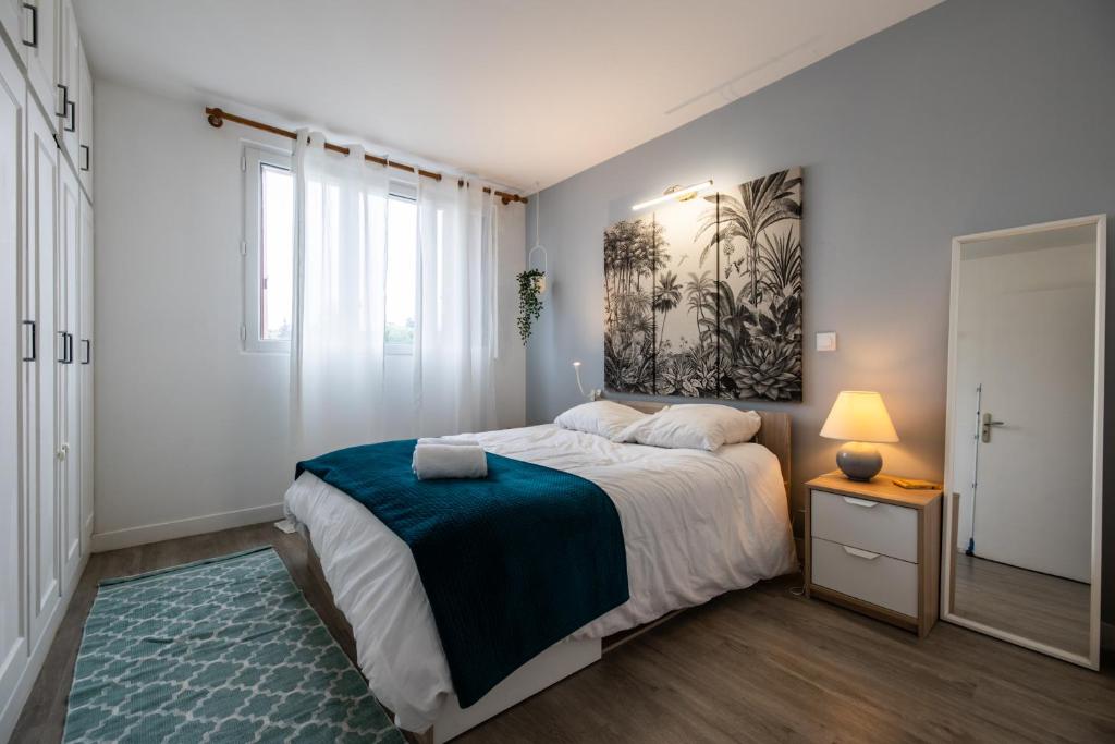 ein Schlafzimmer mit einem Bett und einem Wandgemälde in der Unterkunft Appartement cosy et lumineux-parking gratuit- proche de Paris in LʼHay-les-Roses