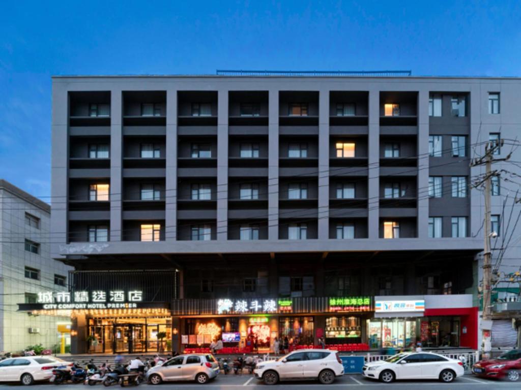 a large building with cars parked in front of it at Premier City Comfort Hotel Xuzhou Suning Square in Xuzhou