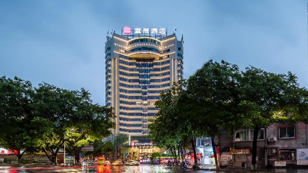 a tall building in the middle of a city at Echarm Hotel Wuzhou Wangcheng Plaza Longmumiao Sanzongfu in Wuzhou