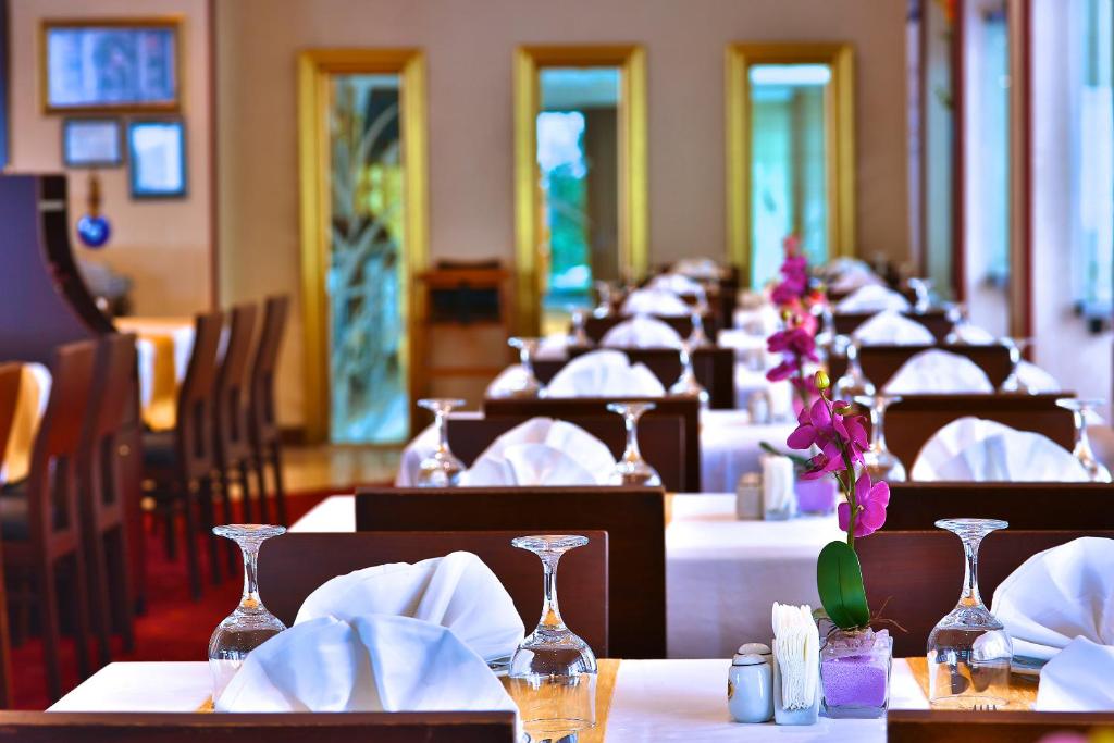 a row of tables with white napkins and flowers on them at Mosaic Hotel Old City -Special Category in Istanbul