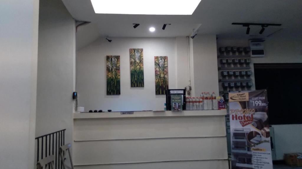 a store with a counter with three paintings on the wall at Airport Hotel in Karanganyar