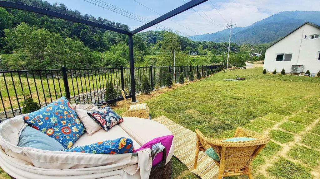 a couch on a porch with a view of a field at Seorak Jaeins Garden in Yangyang