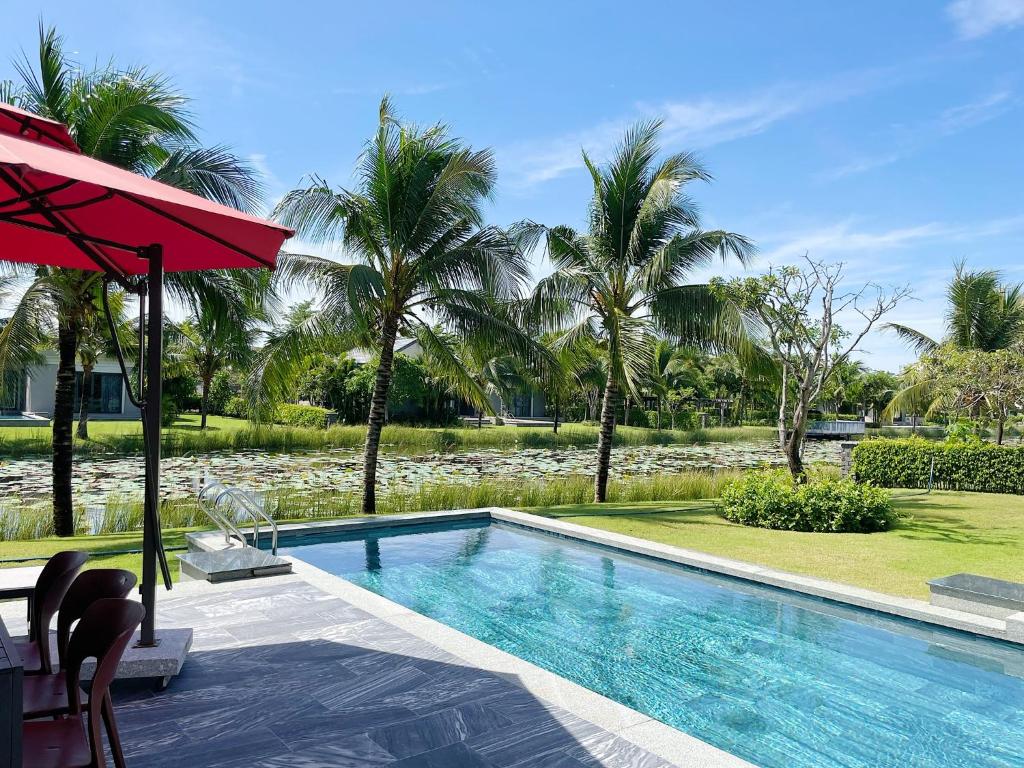 basen z palmami i ośrodek w obiekcie Mimi Coastar Villa w mieście Hồ Tràm