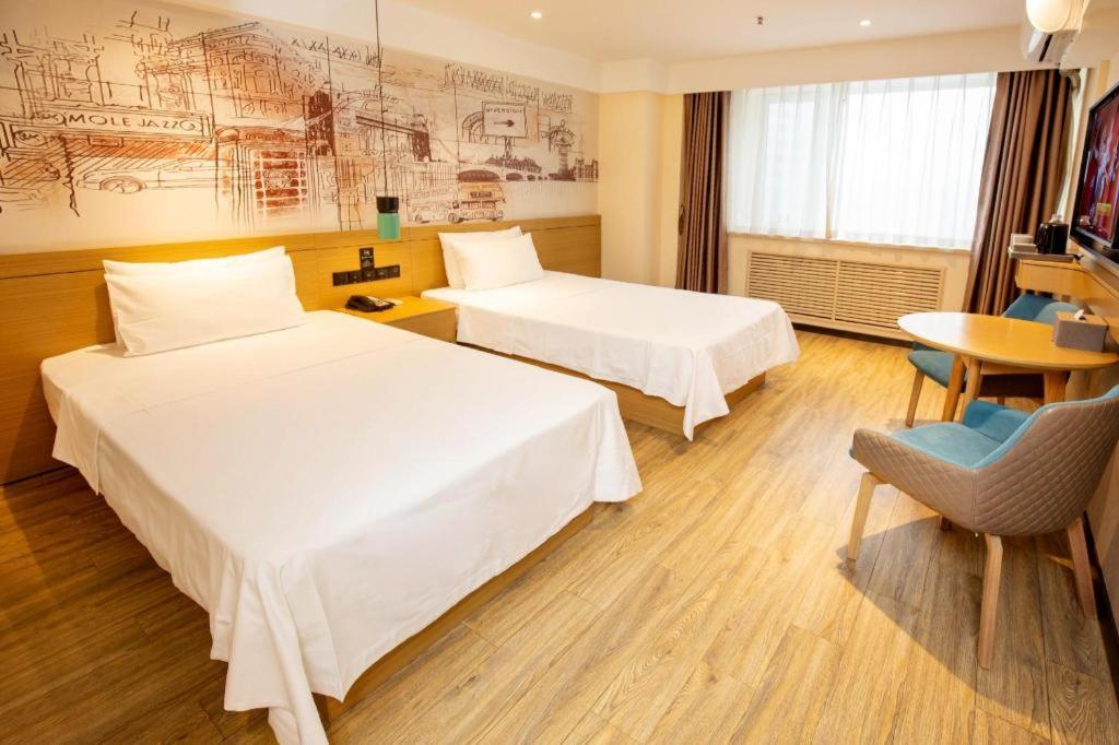 سرير أو أسرّة في غرفة في Hanting Hotel Changchun Gongnong Square Metro Station