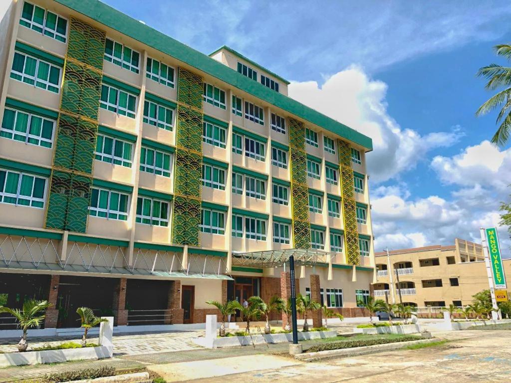 um edifício com plantas ao lado dele em Mango Valley Hotel 5 em Olongapo