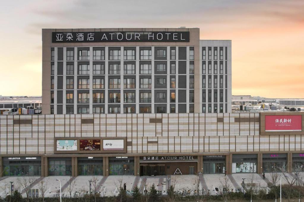 un gran hotel con un cartel encima en Atour Hotel Tianjin Shengtaicheng Maritime Museum, en Binhai