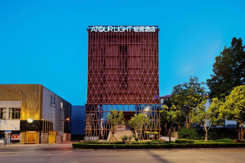 Un edificio con un cartel al costado. en Atour X Hotel Jinan Jingshi Road Provincial Sports Center, en Jinan