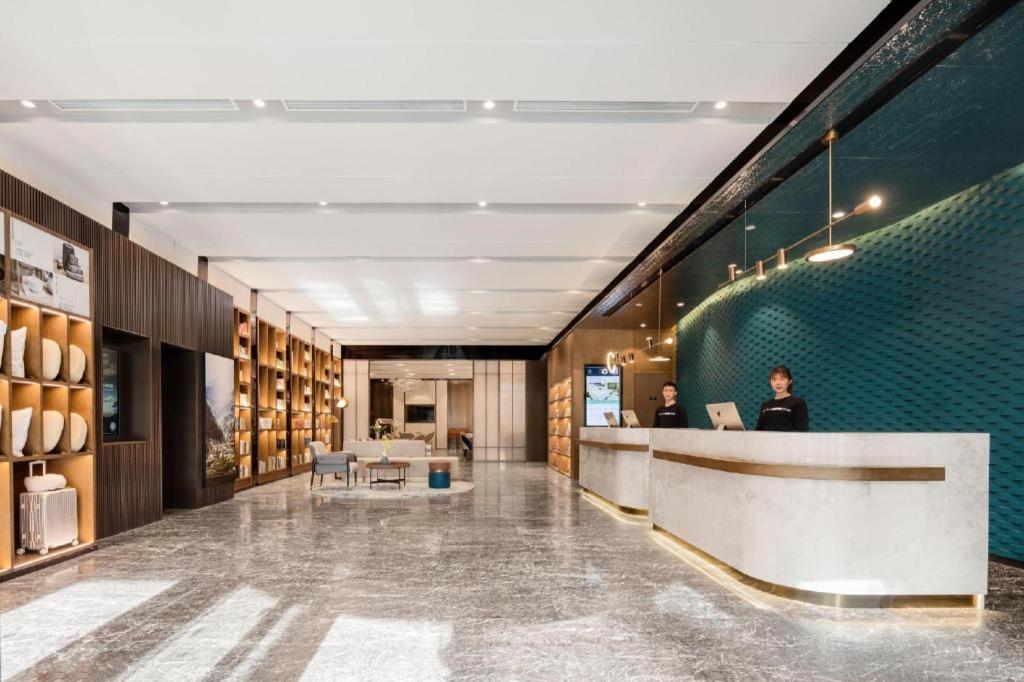 a lobby with two people sitting at a desk at Atour Hotel Taiyuan Inner Ring in Taiyuan