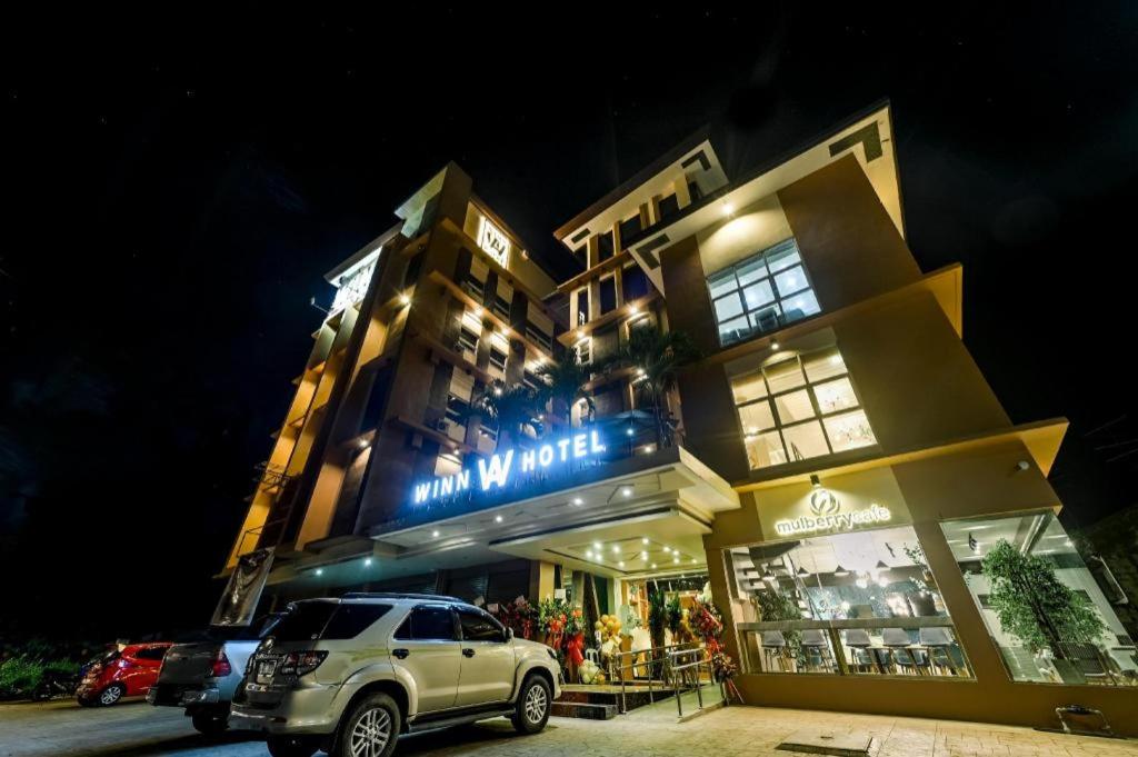 uma SUV estacionada em frente a um edifício à noite em WINN Hotel em Zamboanga
