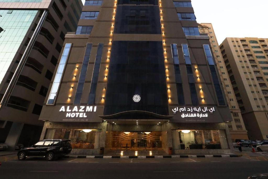 un edificio con un'auto parcheggiata di fronte di ALAZMI HOTEL a Al Khān