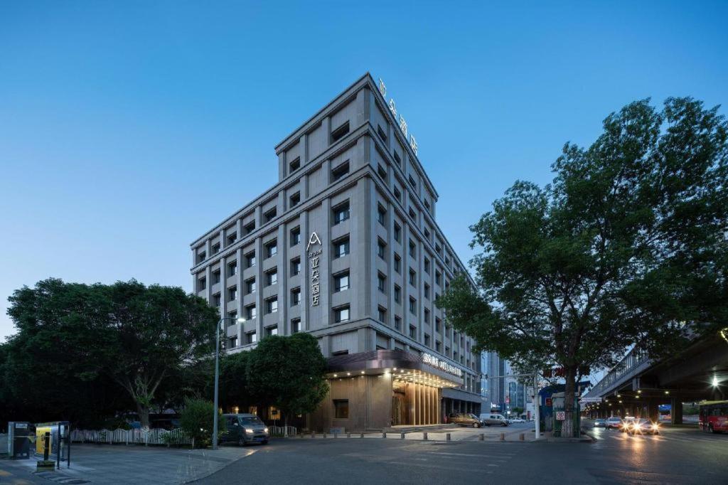 ein hohes weißes Gebäude in einer Stadtstraße in der Unterkunft Atour Hotel Urumqi Municipal Government Nanhu People's Square in Ürümqi