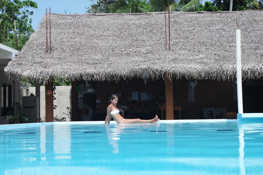 una mujer en bikini sentada en una piscina en Holaa Mirissa, en Mirissa