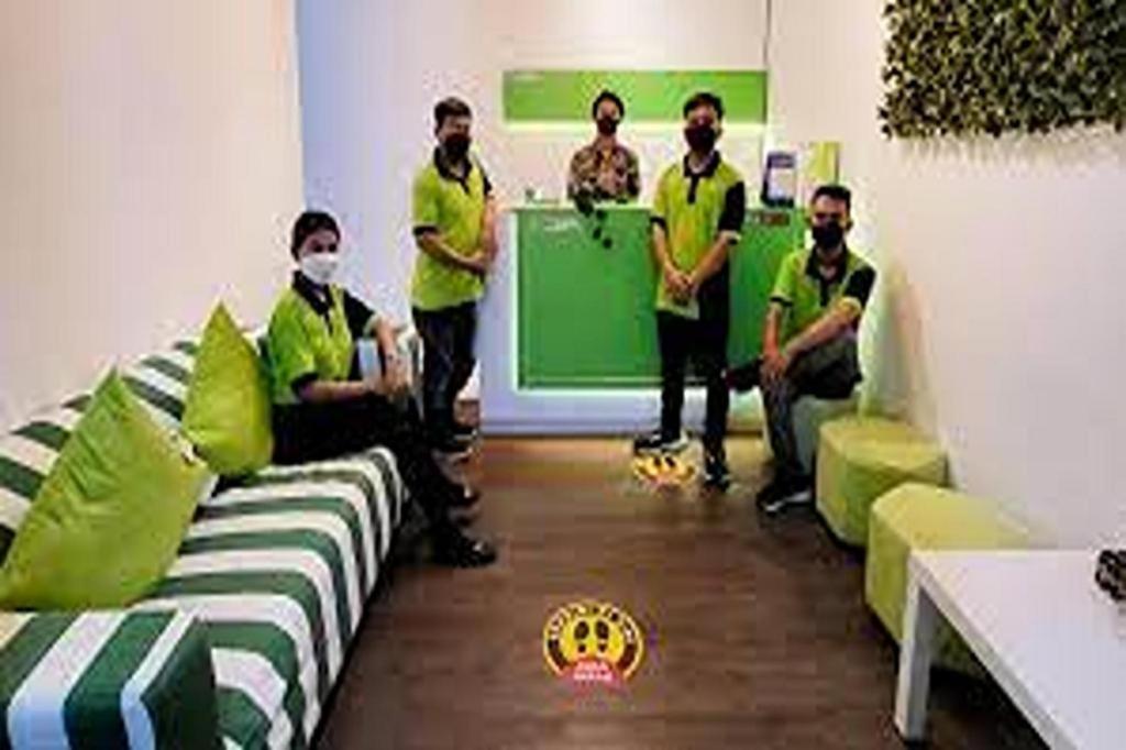 TekoにあるBarata INN By Nature's AEROPOLIS Airport Soetaの緑の家具を備えた部屋の男性グループ