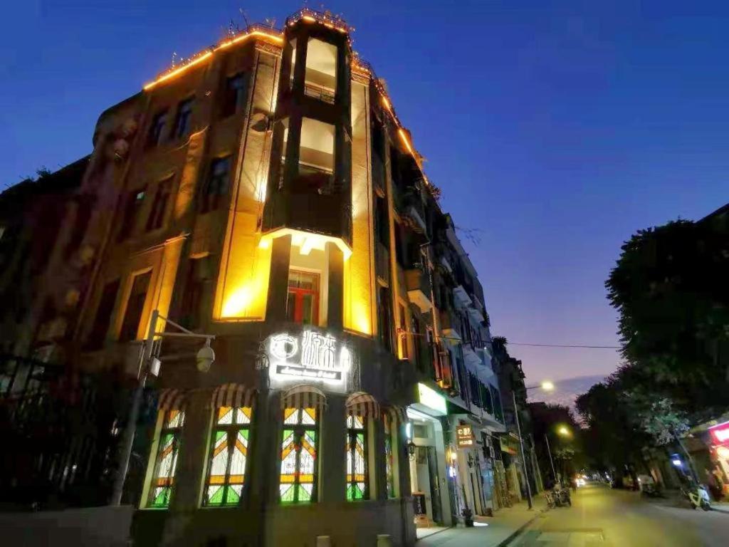 a building with a neon sign on the side of it at Origin Antique House and Hotel in Guangzhou