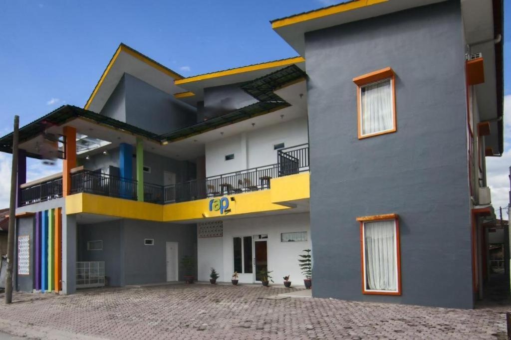 a large house with a colorful balcony on it at RAP Hotel Balige in Balige