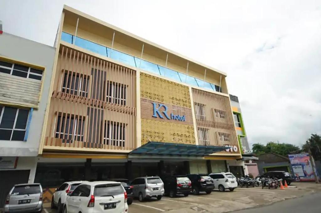 a large building with cars parked in a parking lot at KR Hotel in Palembang