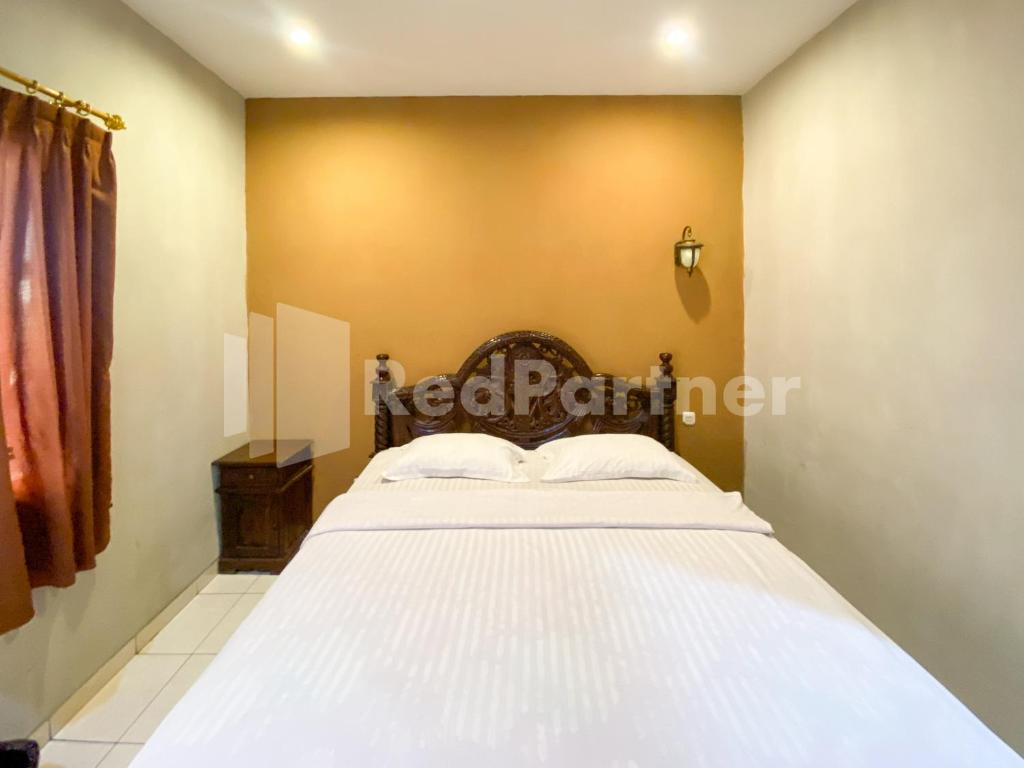 a bedroom with a large white bed in a room at Istana Griya 2 Hotel Solo RedPartner in Solo