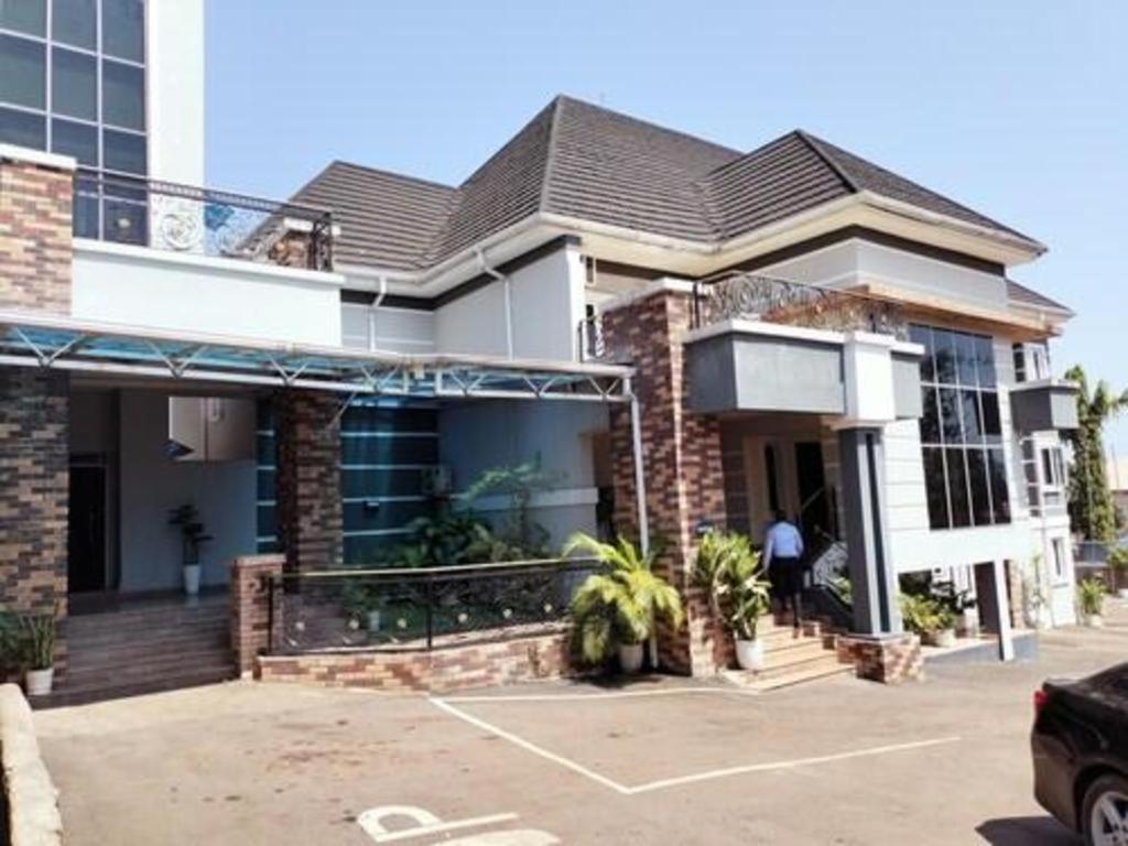 ein Haus mit einem Auto auf einem Parkplatz in der Unterkunft Easton Hill Continental Hotel in Enugu