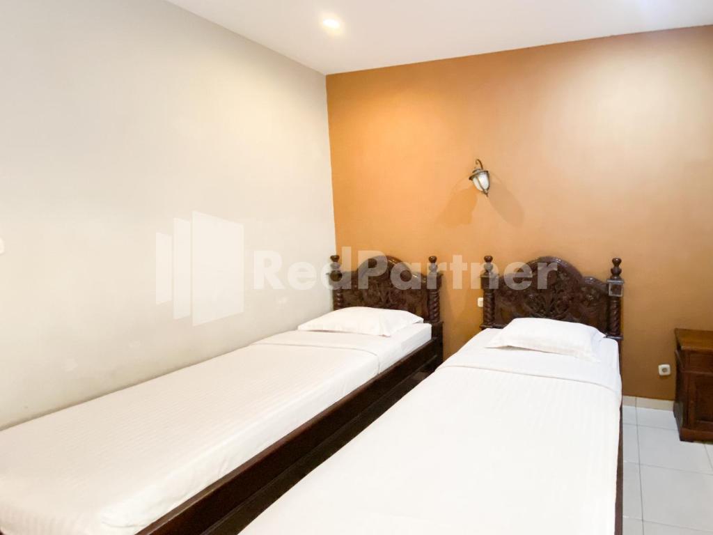 Postel nebo postele na pokoji v ubytování Istana Griya 2 Hotel Solo RedPartner
