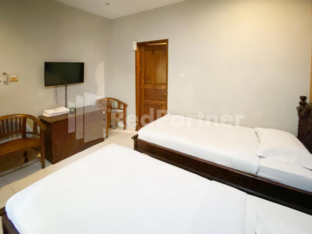 Postel nebo postele na pokoji v ubytování Istana Griya 2 Hotel Solo RedPartner