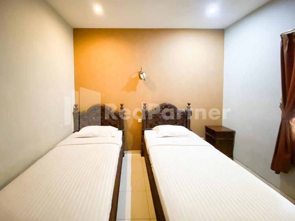 Postel nebo postele na pokoji v ubytování Istana Griya 2 Hotel Solo RedPartner