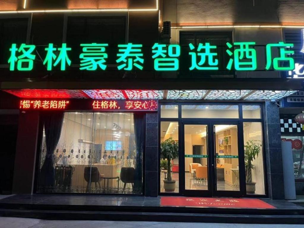 a store with a sign on the side of a building at GreenTree Inn Express Dongying Municipal Governemnt Wanda Plaza in Dongying