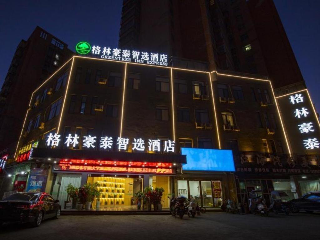budynek z napisem na przodzie w nocy w obiekcie GreenTree Inn Express Fuyang University Town West High-Speed Railway Station w Fuyang