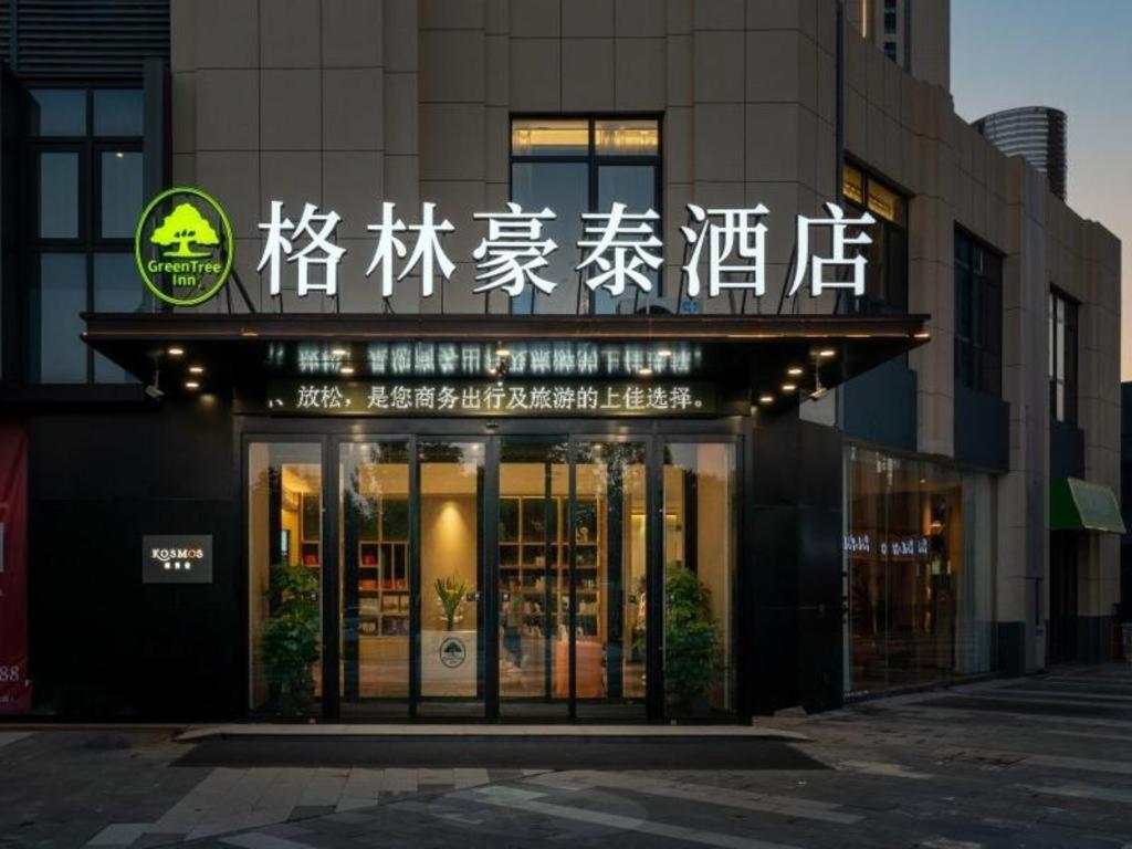 een winkel voor een gebouw met een opschrift erop bij GreenTree Inn Jinan West Station Exhibition Center in Jinan