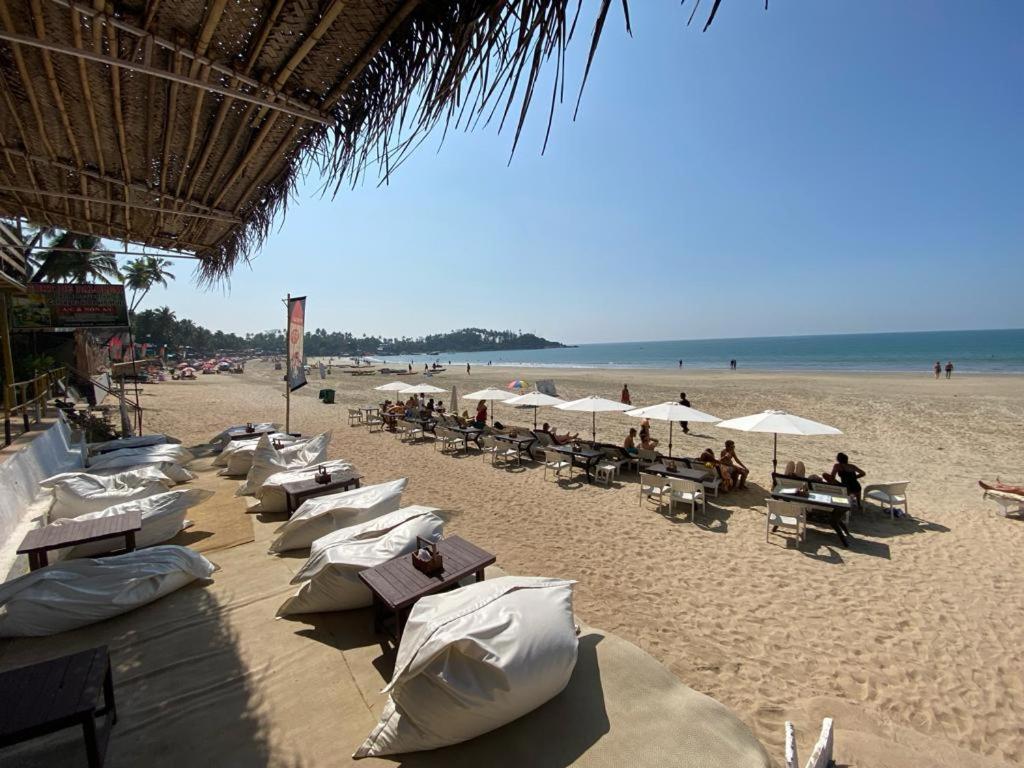 a beach with a bunch of chairs and umbrellas at INAS OCEAN FRONT in Canacona